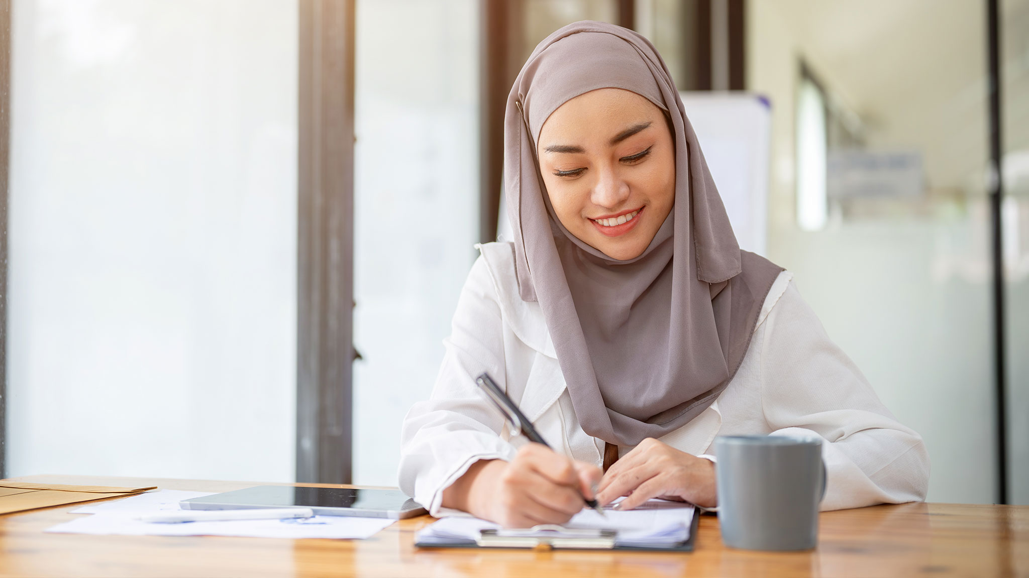 Woman happily filling out payroll forms